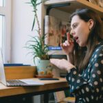 Young female student learning sign language during online lesson