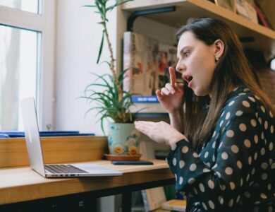 Young female student learning sign language during online lesson