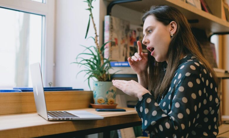 Young female student learning sign language during online lesson