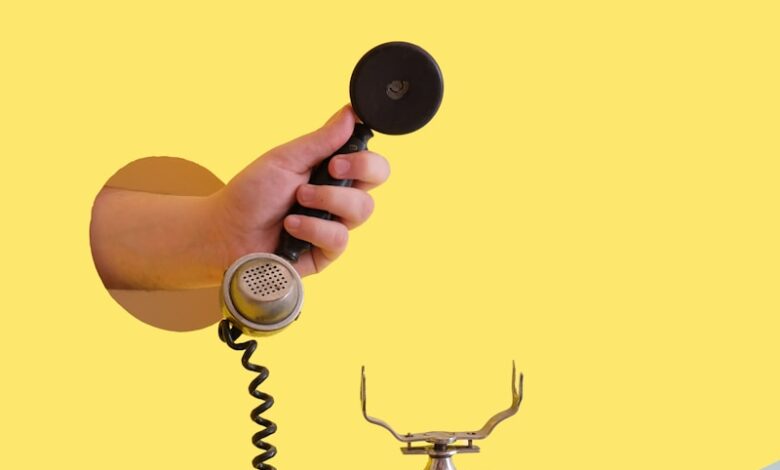 person holding black rotary telephone