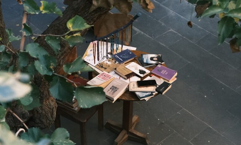 A wooden bench sitting under a tree filled with books