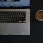 a laptop with a bowl of food