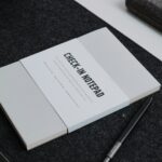 a book sitting on top of a table next to a pen