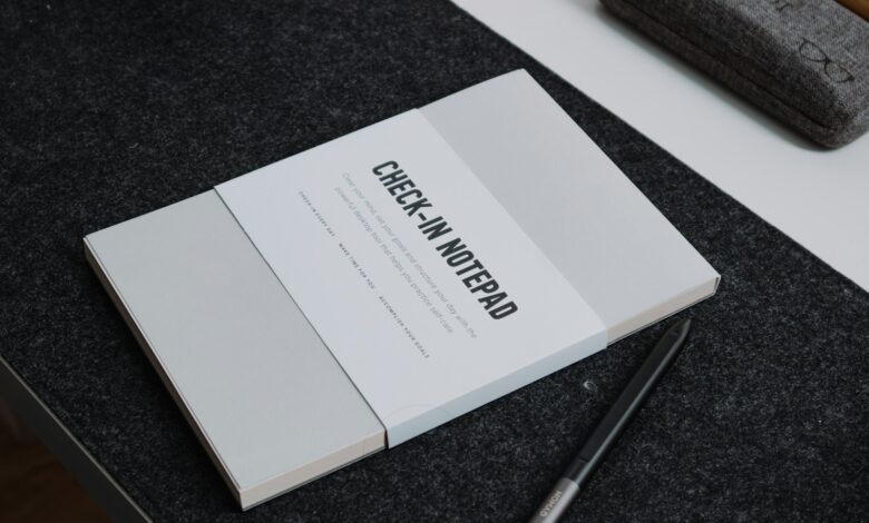 a book sitting on top of a table next to a pen