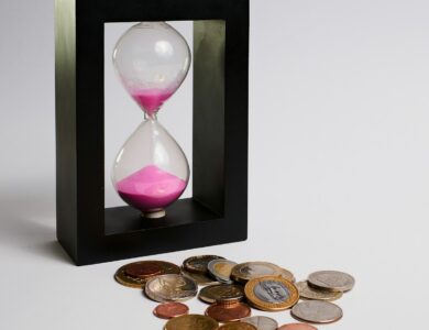 clear hour glass with coins