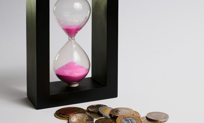 clear hour glass with coins