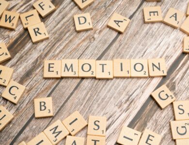 scrabble tiles spelling the word emotion on a wooden surface