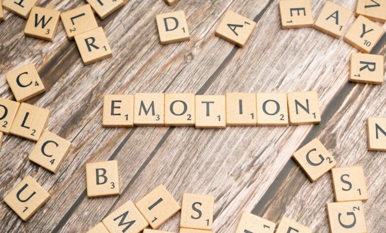 scrabble tiles spelling the word emotion on a wooden surface