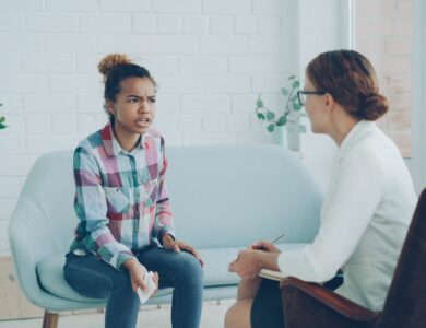 A woman talks to a therapist in an office.
