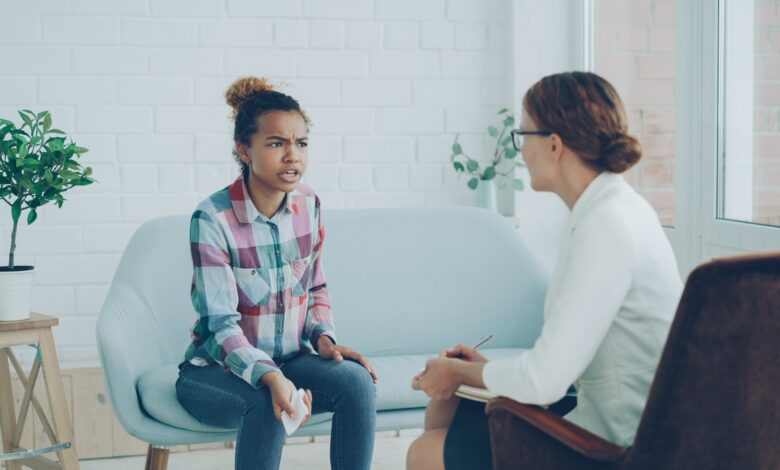 A woman talks to a therapist in an office.