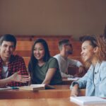 Students talking and laughing in a lecture hall.