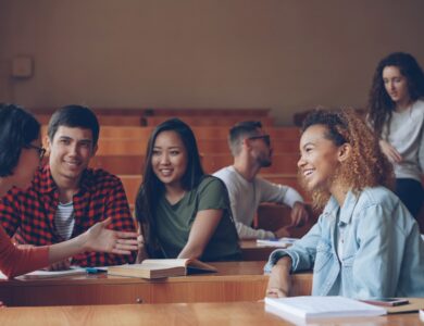 Students talking and laughing in a lecture hall.