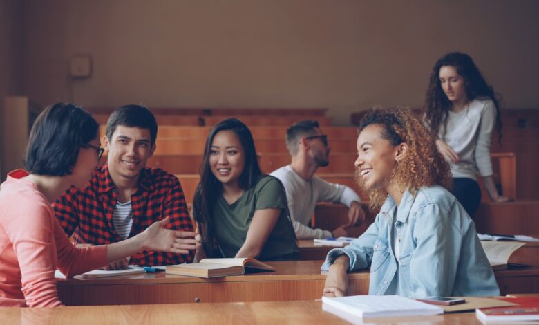Students talking and laughing in a lecture hall.