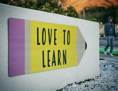 love to learn pencil signage on wall near walking man